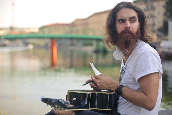 Musiker Schreibt Lieder Auf Papier Über Seine Gitarre — Stockfoto