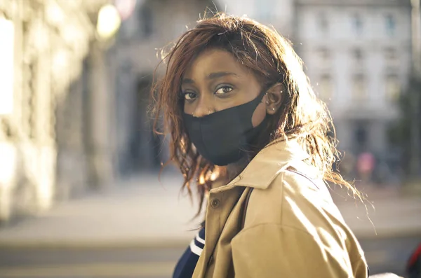 戴着面具的年轻黑人妇女在街上的画像 — 图库照片