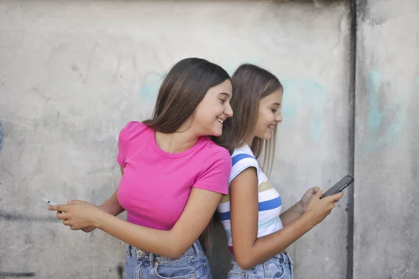 两个年轻姑娘用智能手机 — 图库照片