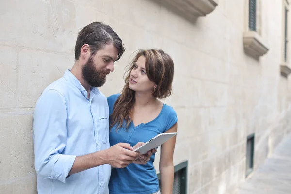 Elinde tabletle sokakta duran bir çift portresi.