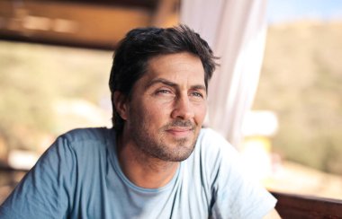 Açık bir kafede genç bir adamın portresi.