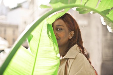 Genç siyah kadın bir ağacın yaprağının altında