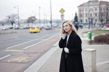 Sokakta siyah ceketli genç bir kadının portresi.