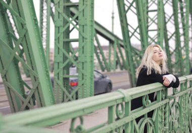 Sokakta siyah ceketli genç bir kadının portresi.