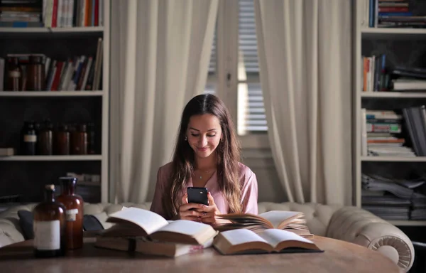 Jonge Vrouw Studeert Met Boeken Maakt Gebruik Van Een Smartphone — Stockfoto