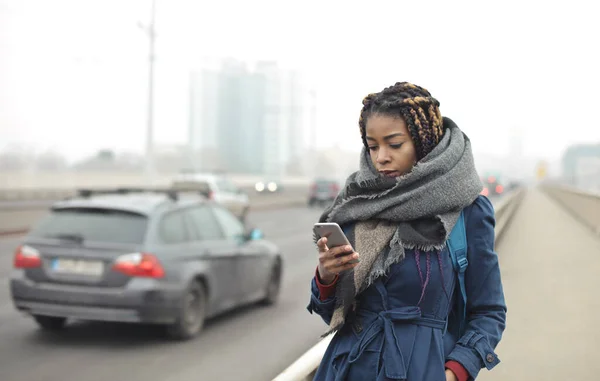 Young Woman Walks Street Reading Smartphone — Photo