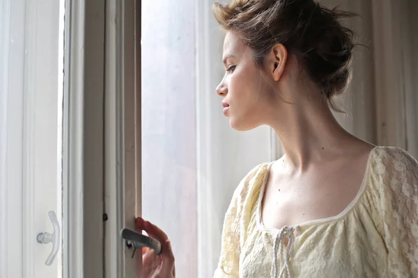 Genç Kadın Pencereden Izliyor — Stok fotoğraf
