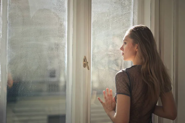 Junge Frau Lehnt Fensterscheibe — Stockfoto