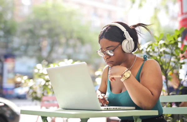 若い女性は外のカフェでコンピューターを使い — ストック写真