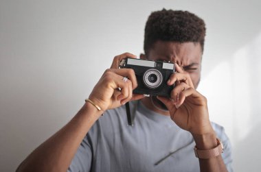 Genç adam fotoğraf makinesiyle fotoğraf çekiyor.
