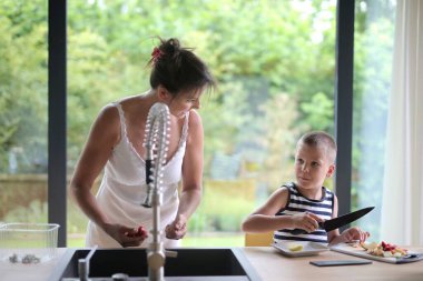 Anne ve oğul mutfakta.