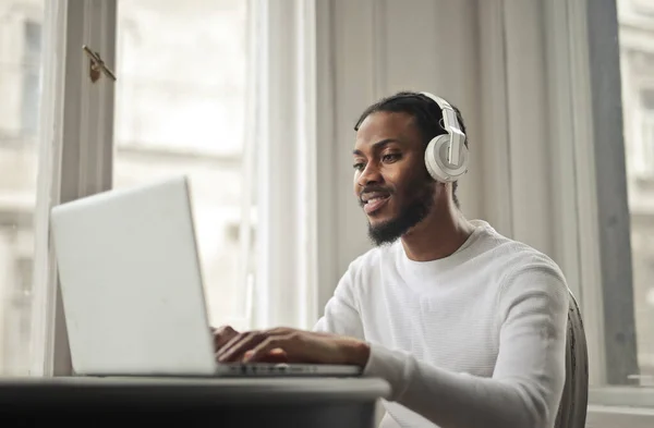 Νεαρός Άνδρας Σπουδάζει Έναν Υπολογιστή Ακούγοντας Μουσική — Φωτογραφία Αρχείου