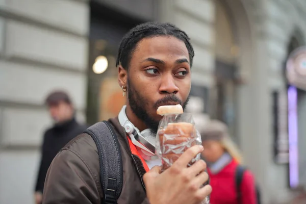Молодой Человек Ест Хлеб Улице — стоковое фото