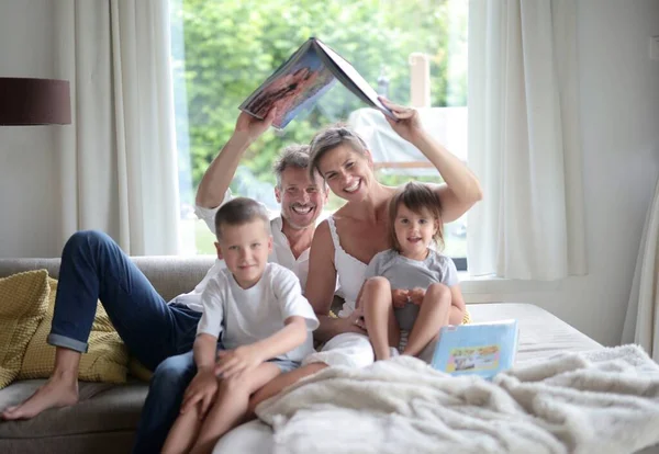 Heureuse Famille Sur Canapé Avec Livre Pointant Vers Toit Une — Photo