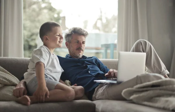 爸爸和儿子在沙发上用电脑 — 图库照片