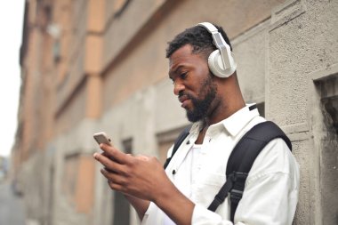 Sokakta akıllı telefonu olan genç bir adam.