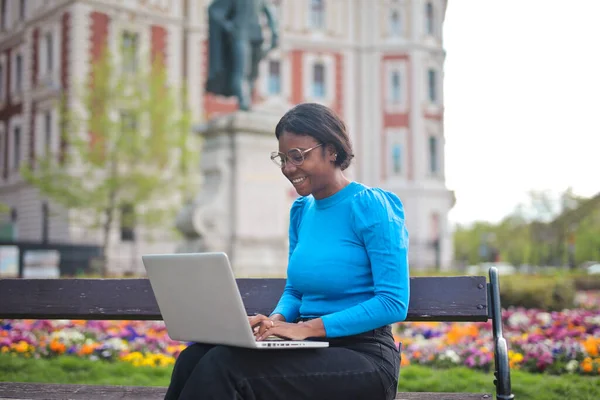 Jonge Vrouw Maakt Gebruik Van Een Laptop Een Bank Stad — Stockfoto