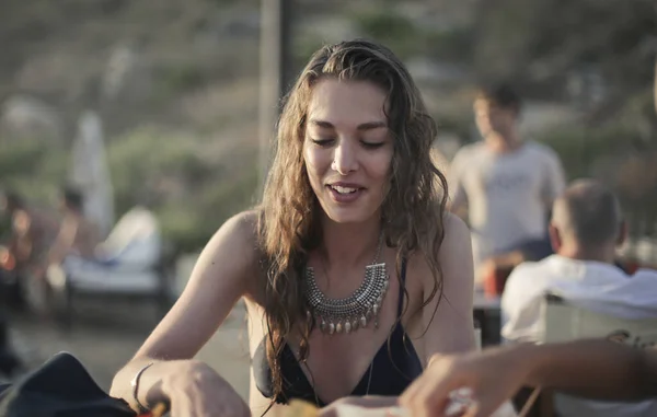 若い女性はビーチのレストランで食事をします — ストック写真