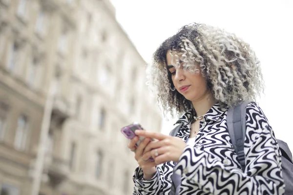 通りでスマート フォンを持つ若い女性 — ストック写真