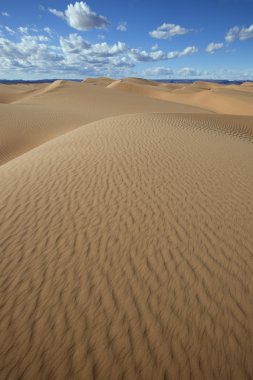 Sahara çöl kumulları ile bulutlu gökyüzü mavi.