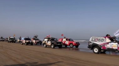 Essaouira, Marakeş, Fas - 2 Ekim 2021: Rallye Aicha des Gazelles 2021. Sunum seremonisi için rallye 2021 'in sonunda Essaouira sahiline arabaların varışı. İsviçre bayrağı.