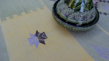 El yapımı, geleneksel Fas kaktüsü ipeği (Sabra ipeği), halı, nane yeşili bir halı üzerinde dekoratif yeşil bir tagine (tajine) ile servis ediliyor..