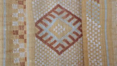 Katlanmış, el yapımı, geleneksel, Fas kaktüsü ipeği (Sabra ipeği) halı, sarı halı. Yakın plan soyut geometrik desenler, Berber tasarımı ile el dokuması.