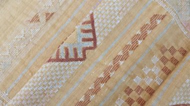 Katlanmış, el yapımı, geleneksel, Fas kaktüsü ipeği (Sabra ipeği) halı, sarı halı. Yakın plan soyut geometrik desenler, Berber tasarımı ile el dokuması.