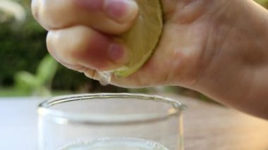 Limon cam bir şişeye sıkışıyor ve saf limon suyu üretiliyor. C vitamini arka plan görüntüleri, sağlıklı organik gıda yaşam tarzı. Yavaş çekim görüntüleri.