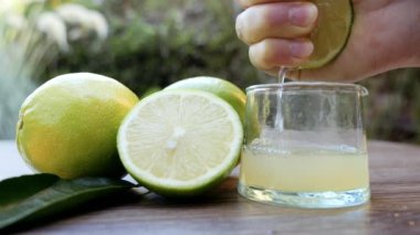 Limon cam bir şişeye sıkışıyor ve saf limon suyu üretiliyor. C vitamini arka plan görüntüleri, sağlıklı organik gıda yaşam tarzı. Yavaş çekim görüntüleri.