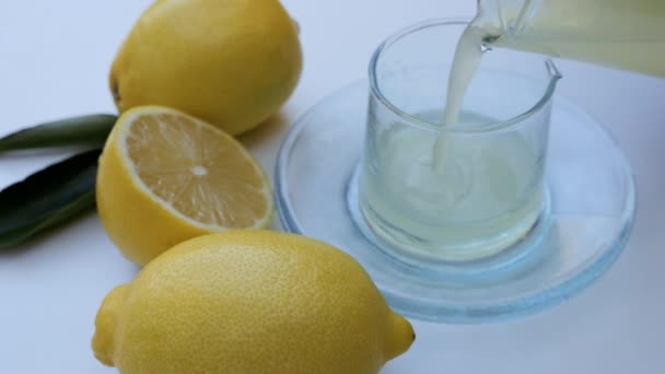 生絞りの純レモン汁をグラスボトルに流し込みます 背景映像健康的なライフスタイル スローモーション映像 — ストック動画