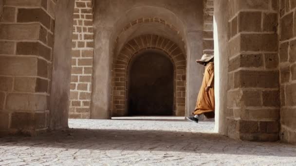 Tradičně Oblečený Marocký Muž Kapucí Slaměným Kloboukem Prochází Klenutým Vchodem — Stock video