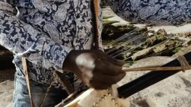 Senegalli bir adam geleneksel bir kora teli çalar. Geleneksel Afro Afrika müziği sık sık sokaklarda, düğünlerde ve festivallerde çalıyordu. 4k