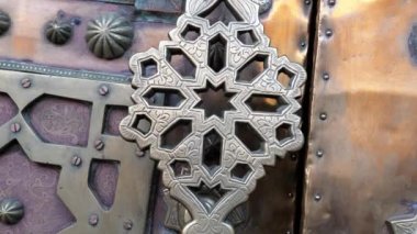 Iron brass door handle, knocker in a traditional Moroccan Islamic geometric shape design. Intricate handmade carved metalwork. 4k