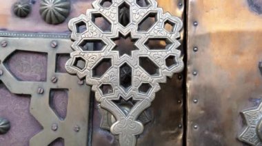 Demir pirinç kapı kolu, geleneksel Fas İslami geometrik şekil tasarımında kapı tokmağı. Karmaşık el yapımı metal işçiliği. 4k