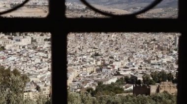 View of the old town of Fez (Fes), Morocco, shot through an iron fence grid. The Medina of Fez is a famous touristic travel destination and UNESCO World Heritage site. 4k, establishing shot.