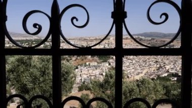 View of the old town of Fez (Fes), Morocco, shot through an iron fence grid. The Medina of Fez is a famous touristic travel destination and UNESCO World Heritage site. 4k, establishing shot.