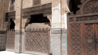 Fez, Morocco - July 24, 2022: Interior architecture of the Madrasa (medersa) Bou Inania, a koranic school, with mosque, in the Medina of Fez (Fes), Morocco. Landmark and important travel destination of Fes. 4k footage.
