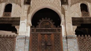Fez, Morocco - July 24, 2022: Interior architecture of the Madrasa (medersa) Bou Inania, a koranic school, with mosque, in the Medina of Fez (Fes), Morocco. Landmark and important travel destination of Fes. 4k footage.