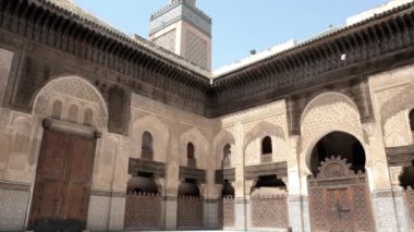 Fez, Morocco - July 24, 2022: Interior architecture of the Madrasa (medersa) Bou Inania, a koranic school, with mosque, in the Medina of Fez (Fes), Morocco. Landmark and important travel destination of Fes. 4k footage.