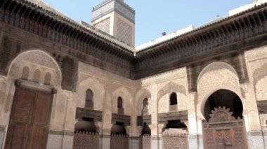 Fez, Morocco - July 24, 2022: Interior architecture of the Madrasa (medersa) Bou Inania, a koranic school, with mosque, in the Medina of Fez (Fes), Morocco. Landmark and important travel destination of Fes. 4k footage.