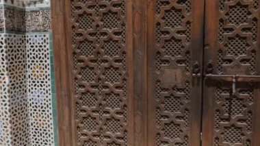 Fez, Morocco - July 24, 2022: Interior architecture of the Madrasa (medersa) Bou Inania, a koranic school, with mosque, in the Medina of Fez (Fes), Morocco. Landmark and important travel destination of Fes. 4k footage.