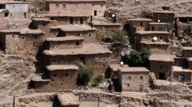 View of a rural village with old stone houses in the High Atlas Mountains in Morocco. Authentic traditional Moroccan country-style architecture. 4k footage.