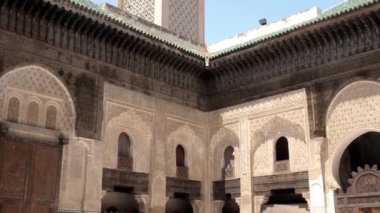 Fez, Morocco - July 24, 2022: Interior architecture of the Madrasa (medersa) Bou Inania, a koranic school, with mosque, in the Medina of Fez (Fes), Morocco. Landmark and important travel destination of Fes. 4k footage.