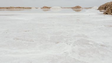 Güney Fas 'taki Tazgha tuz düzlüklerinde, Atlantik okyanus tuzunda doğal deniz tuzu çıkarma, buharlaşma göletleri. 4k içinde doğanın soyut arkaplan görüntüleri.