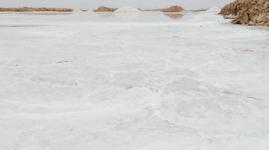 Natural sea salt extraction, evaporation ponds, at the Tazgha salt flats in South Morocco, Atlantic ocean sea salt. Nature abstract background footage in 4k. 