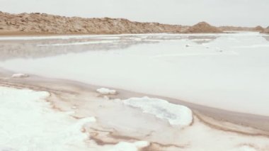 Natural sea salt extraction, evaporation ponds, at the Tazgha salt flats in South Morocco, Atlantic ocean sea salt. Nature abstract background footage in 4k. 