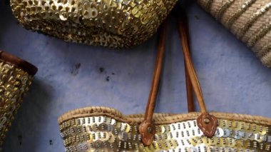 Fashionable trendy handbags with golden and silver paillettes, sequin hanging on wall in Chefchaouen, Morocco. 4k footage.
