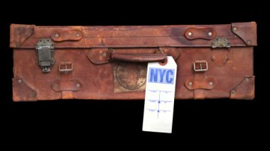 Bir NYC bagaj etiketinin eski bir valizin sapında sallanışının videosunu çekiyorum.