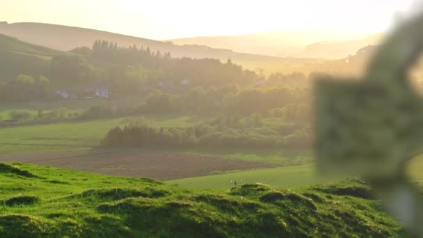 美しいスコットランドの田園地帯の前景に焦点を当てるケルトの十字架の墓石 — ストック動画